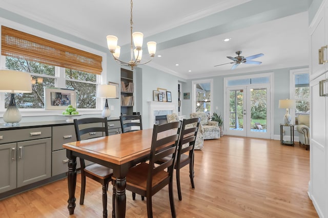 dining space featuring ceiling fan with notable chandelier, light wood-type flooring, and ornamental molding