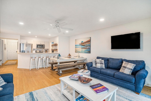 living room with ceiling fan and light hardwood / wood-style floors