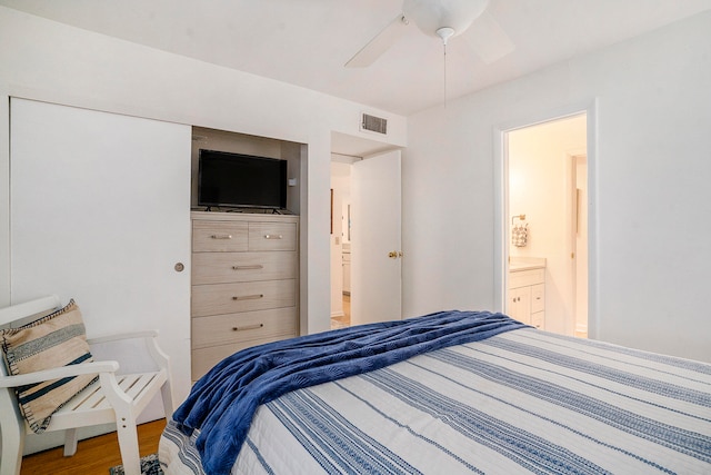 bedroom featuring hardwood / wood-style flooring, ensuite bath, and ceiling fan