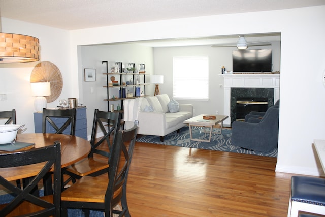 dining room featuring a premium fireplace and hardwood / wood-style floors