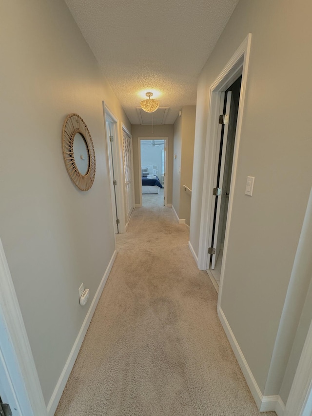 32 41st Ave, Isle Of Palms, SC 29451 - hall featuring attic access, a textured ceiling, light colored carpet, baseboards, and an upstairs landing
