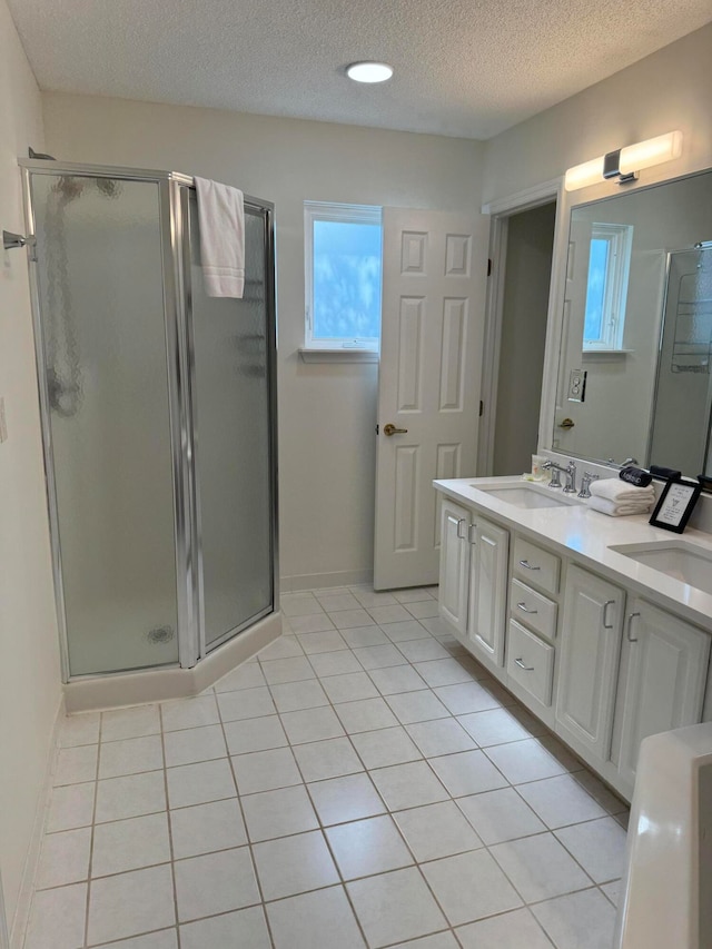 bathroom with vanity, an enclosed shower, and a textured ceiling