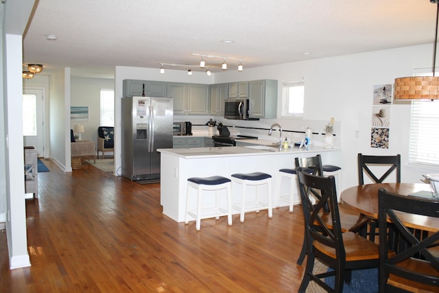 32 41st Ave, Isle Of Palms, SC 29451 - kitchen featuring stainless steel appliances, gray cabinetry, a peninsula, light countertops, and dark wood-type flooring