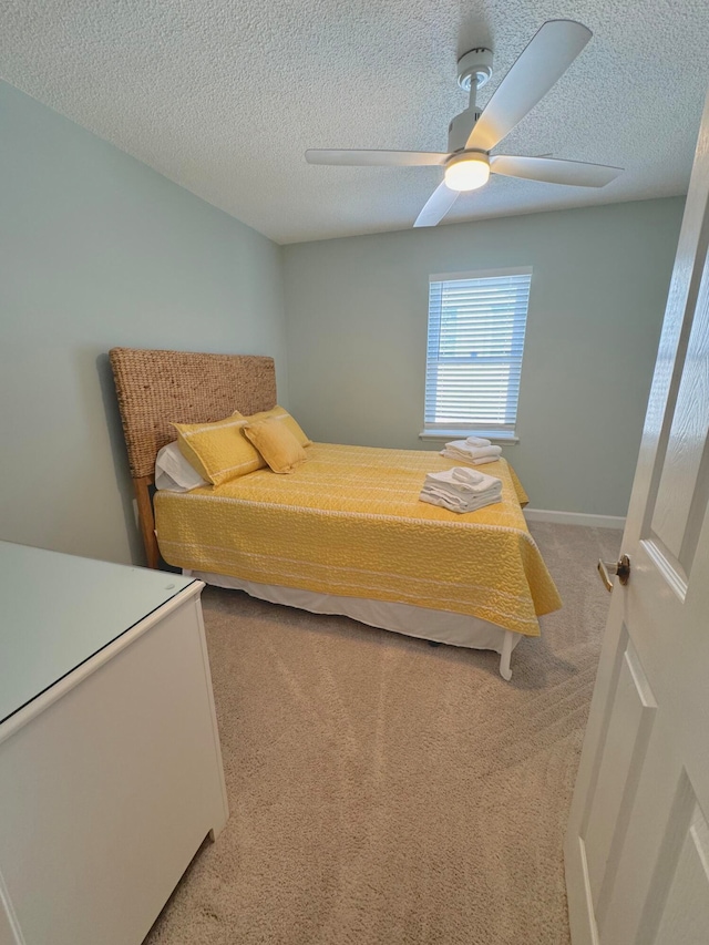 bedroom with a textured ceiling, carpet flooring, and ceiling fan