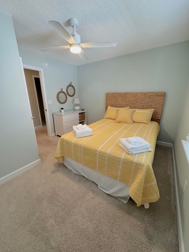 bedroom featuring light carpet, a textured ceiling, and ceiling fan