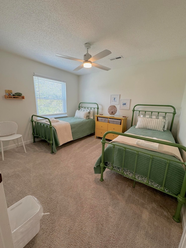 carpeted bedroom with a textured ceiling and ceiling fan