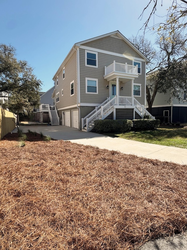 32 41st Ave, Isle Of Palms, SC 29451 - coastal inspired home with stairway, a garage, a balcony, and concrete driveway