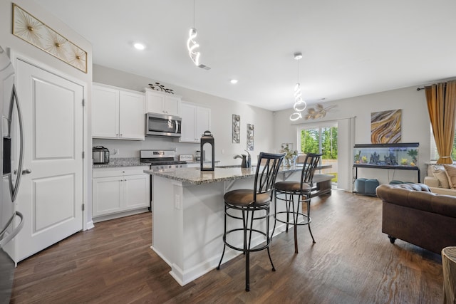 225 N Light Way, Summerville, SC 29486 - kitchen with appliances with stainless steel finishes, dark wood-style flooring, light stone countertops, a kitchen breakfast bar, and recessed lighting