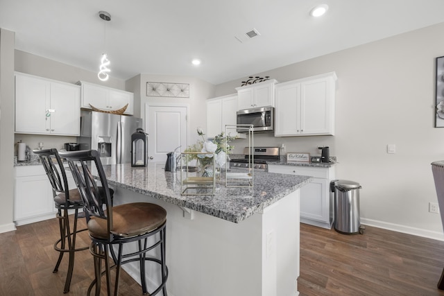 225 N Light Way, Summerville, SC 29486 - kitchen featuring appliances with stainless steel finishes, dark wood-style floors, light stone counters, a kitchen bar, and recessed lighting