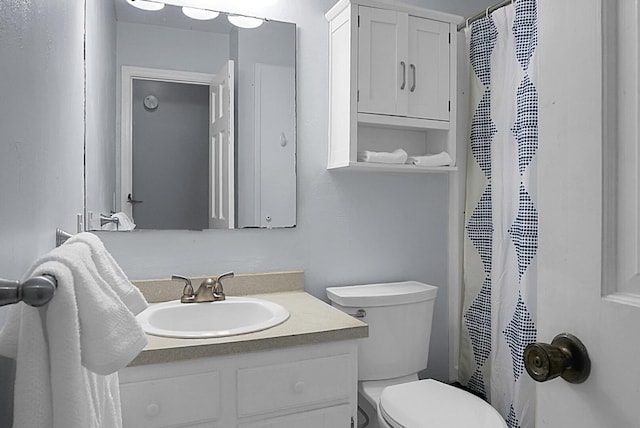 bathroom featuring toilet, curtained shower, and vanity