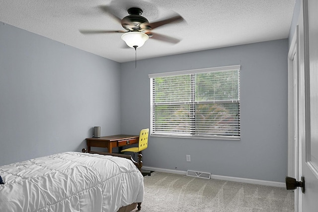 bedroom with ceiling fan, carpet floors, a textured ceiling, baseboards, and visible vents
