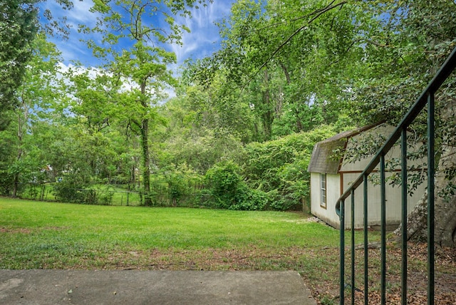 view of yard featuring fence, an outbuilding, and a shed