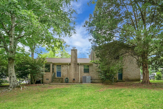 back of property featuring a lawn, cooling unit, a chimney, and entry steps