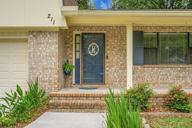 property entrance featuring a porch, brick siding, and an attached garage