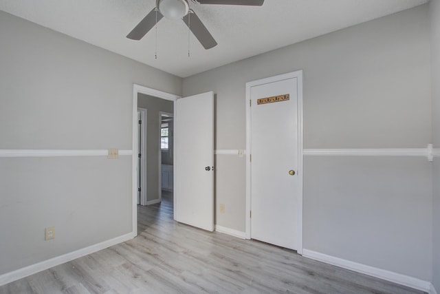 unfurnished bedroom with wood finished floors, a ceiling fan, and baseboards