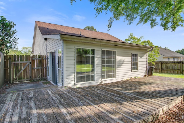 wooden terrace featuring a fenced backyard and a gate