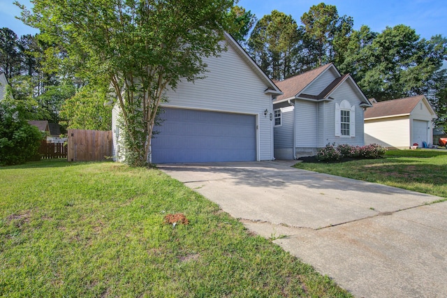 view of front facade with concrete driveway, a front lawn, fence, and an attached garage