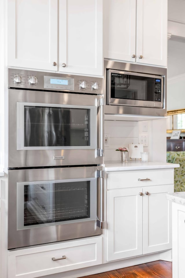 kitchen featuring appliances with stainless steel finishes, light wood-type flooring, and white cabinets