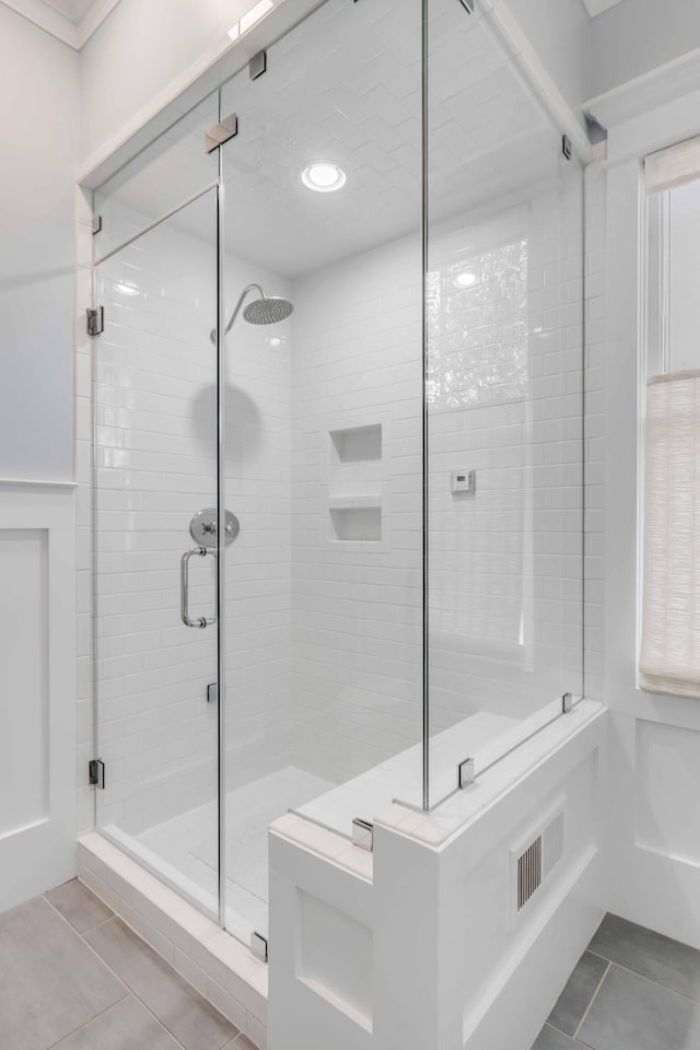 bathroom featuring tile patterned flooring and an enclosed shower