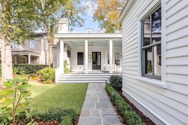 entrance to property with a lawn and covered porch