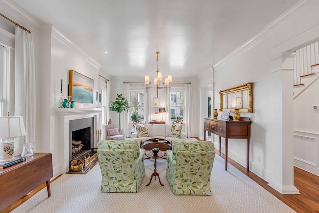 living room featuring crown molding, light hardwood / wood-style flooring, and a notable chandelier