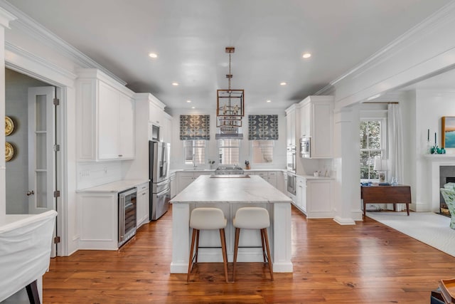 kitchen with appliances with stainless steel finishes, a kitchen island, and white cabinets