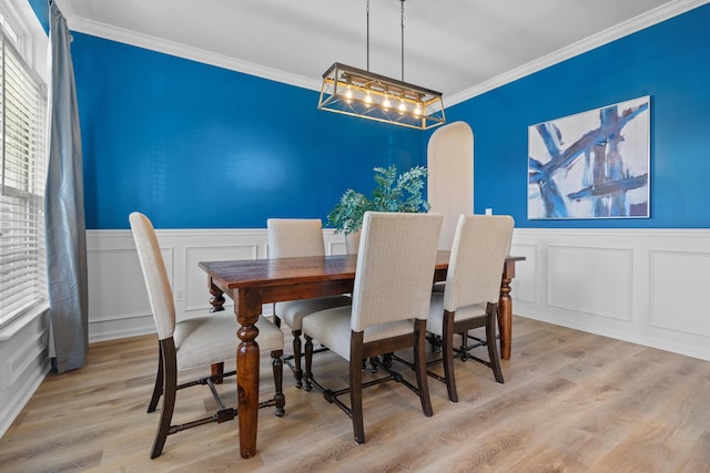 dining space featuring light wood-type flooring and crown molding