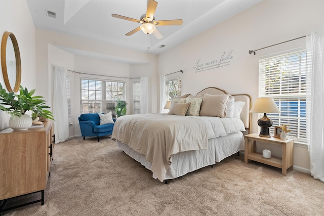 carpeted bedroom featuring ceiling fan and multiple windows