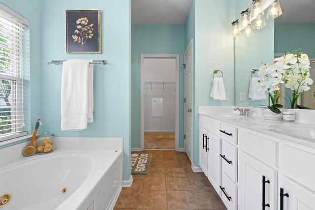 bathroom featuring vanity, a wealth of natural light, tile patterned flooring, and a bath