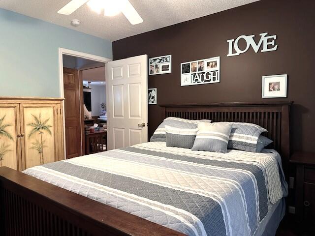 bedroom with ceiling fan and a textured ceiling