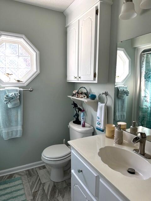 bathroom featuring vanity, toilet, and baseboards