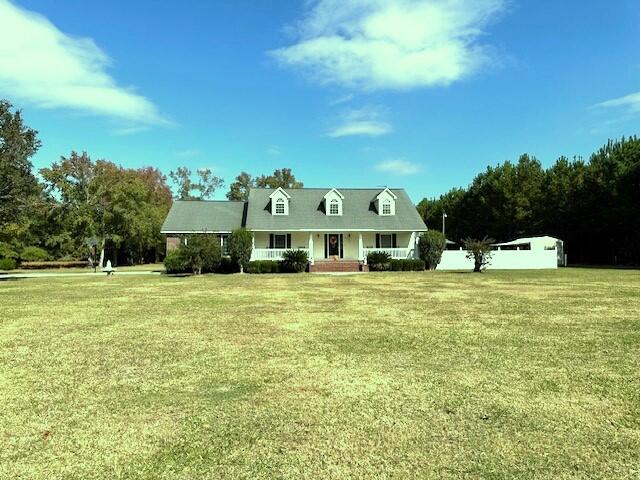 cape cod-style house with a front yard and covered porch