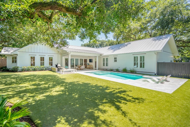 rear view of property featuring a lawn and a patio area