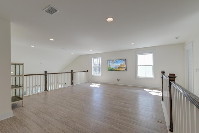 bonus room featuring visible vents, baseboards, lofted ceiling, light wood-style flooring, and recessed lighting