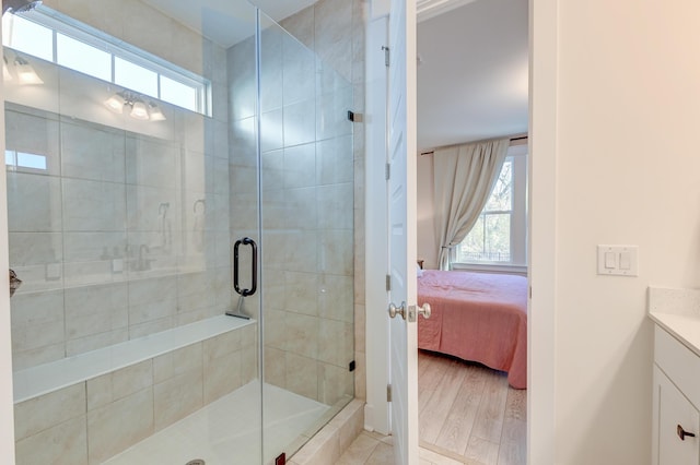 full bath featuring vanity, plenty of natural light, wood finished floors, and a stall shower