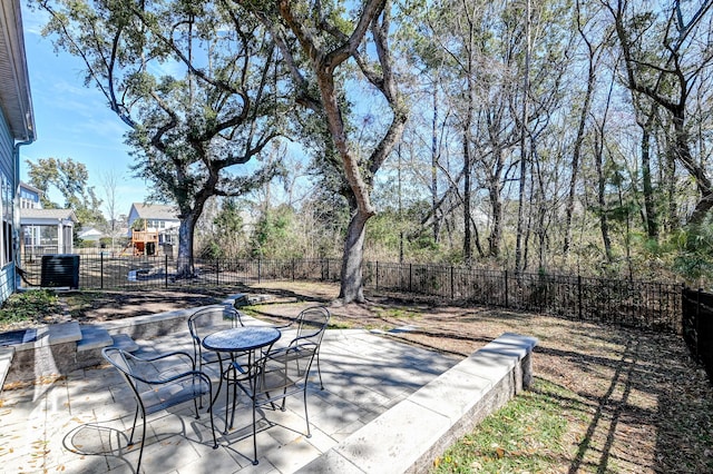 view of patio / terrace with central AC unit, outdoor dining area, and a fenced backyard