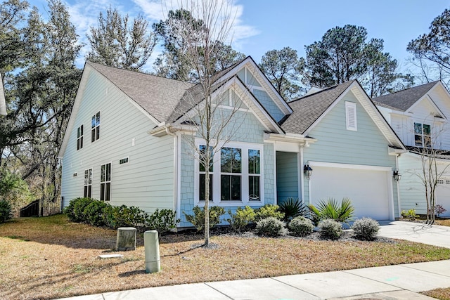 view of front of property with concrete driveway, a garage, and a shingled roof