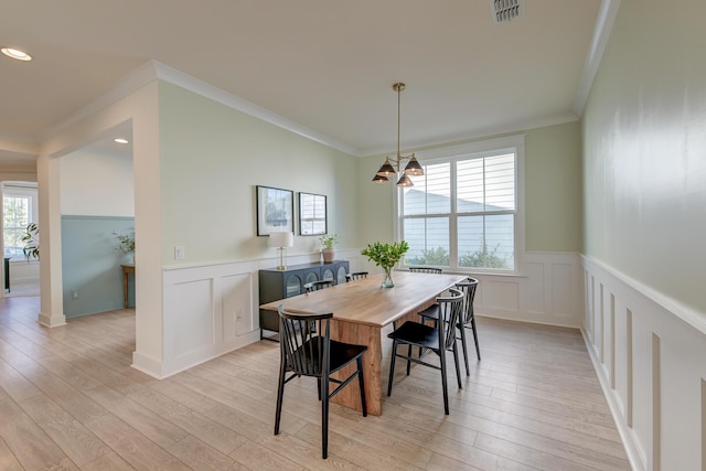 dining room with ornamental molding, visible vents, a chandelier, and light wood-type flooring