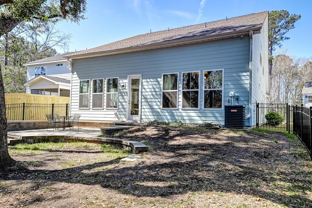 rear view of house with a patio area, fence, and central AC