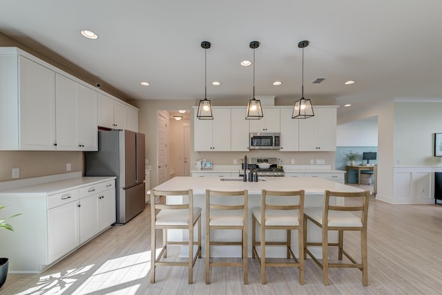 kitchen with visible vents, light wood-style flooring, appliances with stainless steel finishes, and light countertops