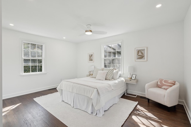 bedroom with dark wood finished floors, multiple windows, and baseboards