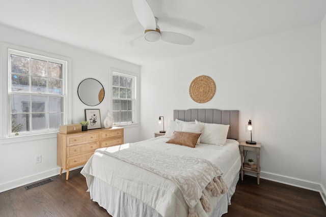 bedroom featuring dark wood-style floors, visible vents, ceiling fan, and baseboards