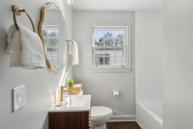 full bathroom featuring toilet, vanity, baseboards, and wood finished floors