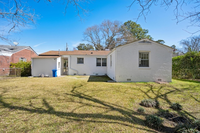 back of house with crawl space, brick siding, a yard, and fence