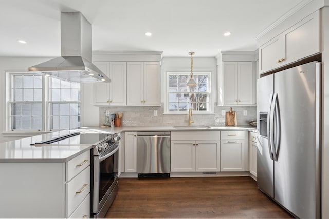 kitchen featuring a peninsula, island exhaust hood, a sink, stainless steel appliances, and light countertops