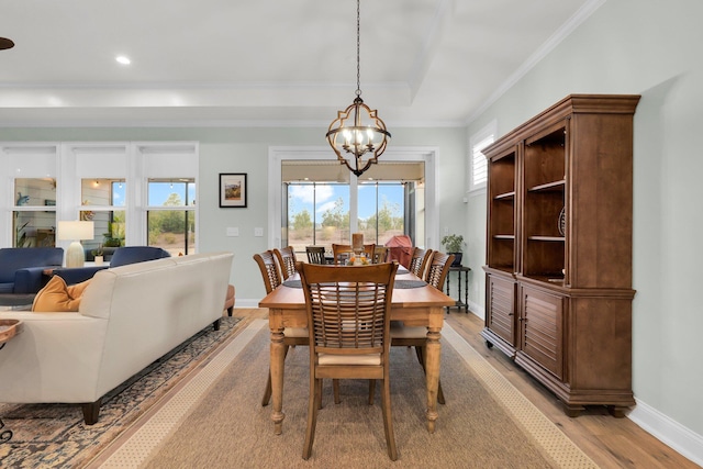 dining area featuring light hardwood / wood-style floors, an inviting chandelier, and ornamental molding