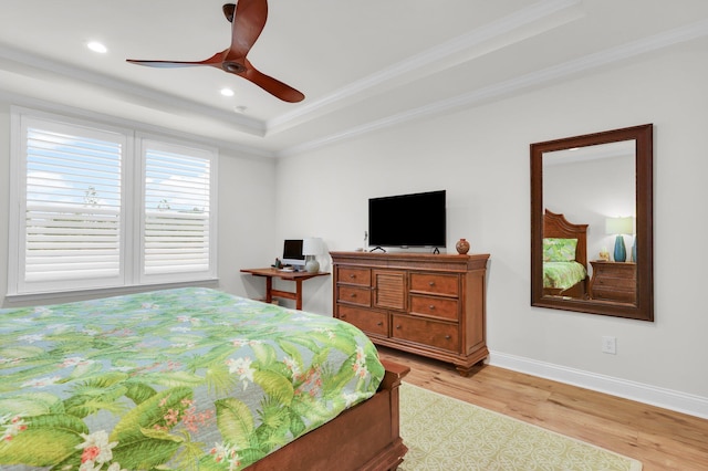 bedroom featuring a raised ceiling, ceiling fan, crown molding, and light hardwood / wood-style flooring