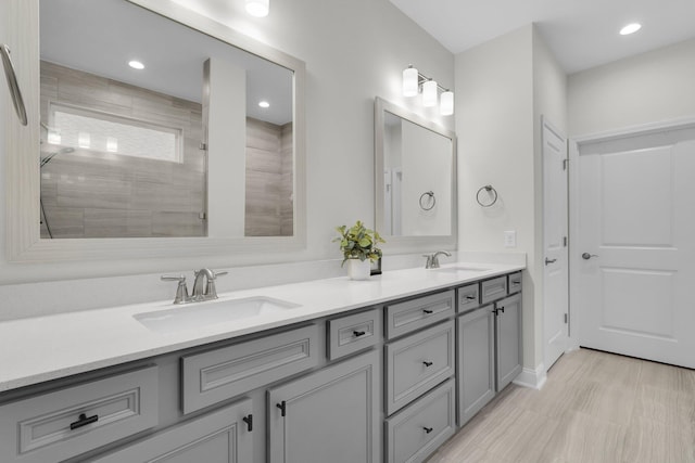 bathroom featuring a tile shower and vanity