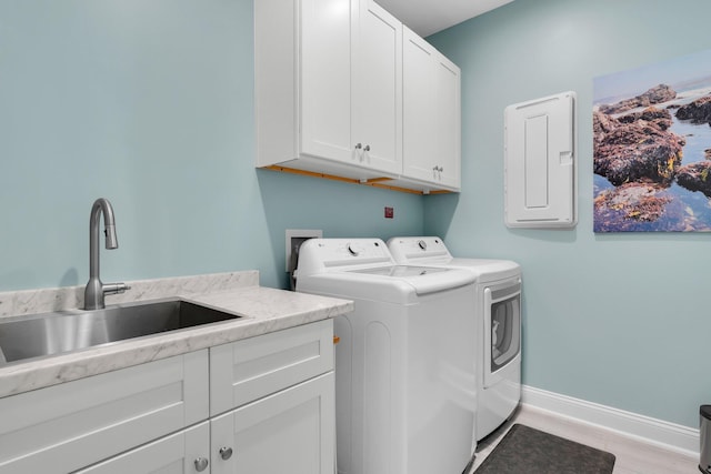 clothes washing area featuring washer and clothes dryer, electric panel, sink, and cabinets