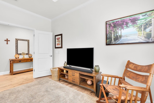 living area featuring crown molding and light hardwood / wood-style flooring